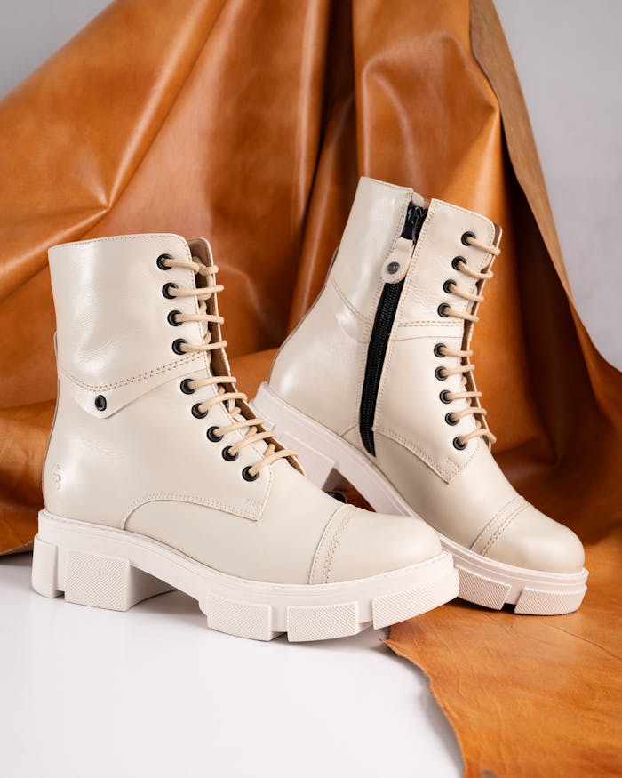 Stylish beige leather boots with lace tie and modern design for fashion highlights.