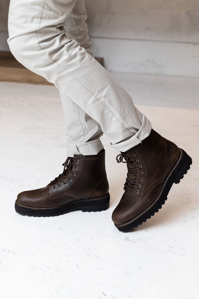 Close-up of brown leather hiking boots in motion, showcasing stylish footwear design for outdoor adventures.